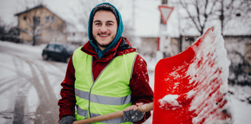 Young worker shoveling snow.