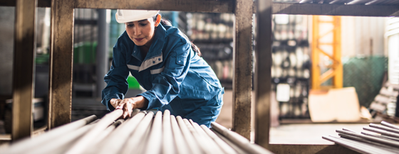 Female Steel Factory Worker at work moving steel poles