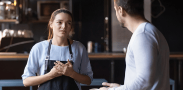 Image of a female worker and male worker talking in a restaurant