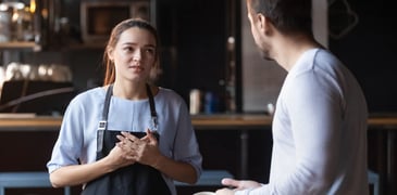 Image d'une travailleuse et d'un travailleur discutant dans un restaurant