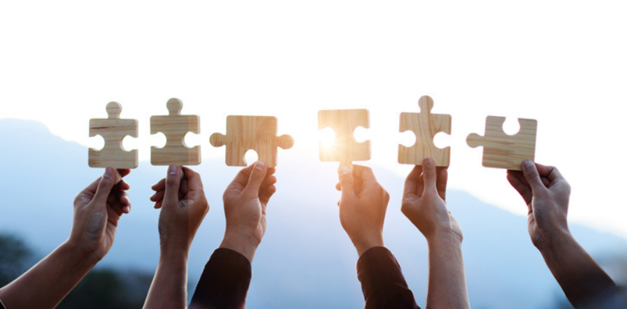 Image of people holding up puzzle pieces