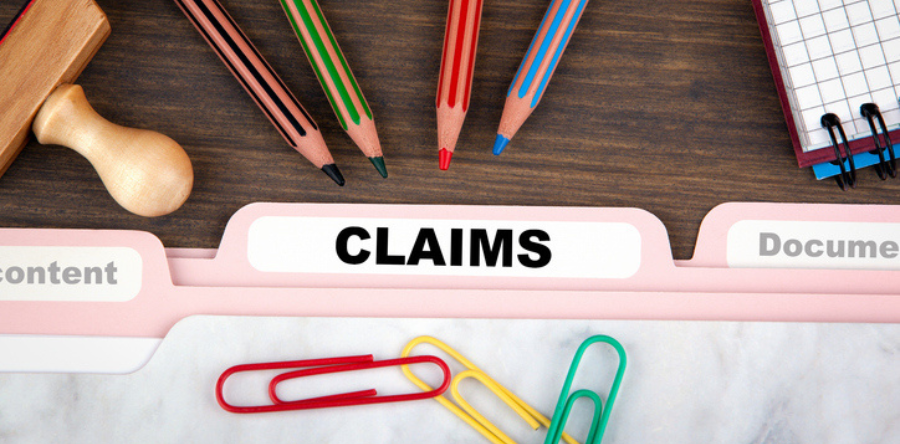 Image of file folders with pencils, paper clips and stamp on desk