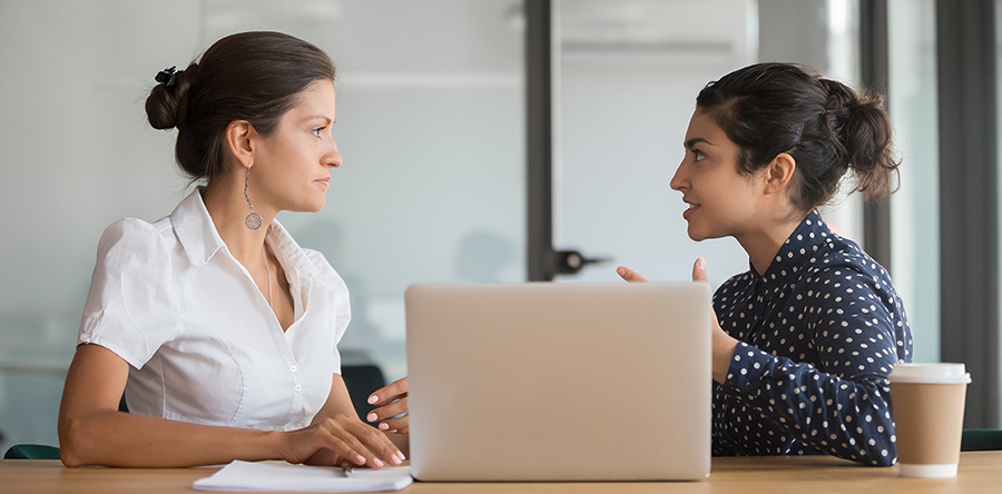 two women sitting down in front of computer havinng a meeting