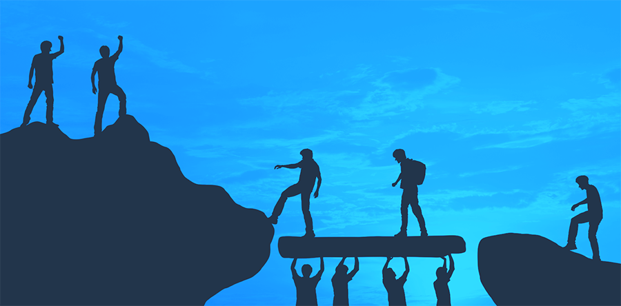 Two people crossing a bridge to get to other side of mountain, four people standing underneath holding it up