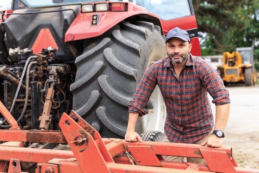 Farmer leadning on his tractor
