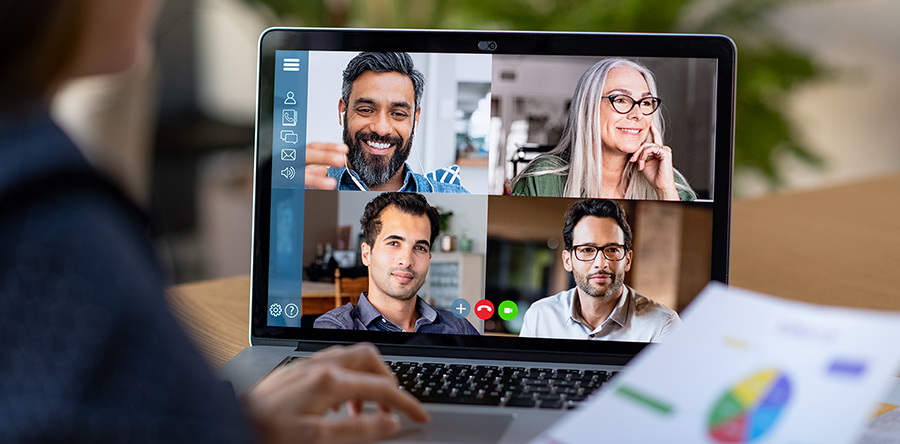 Individual sittin at desk in front of laptop, participating in a web conference call