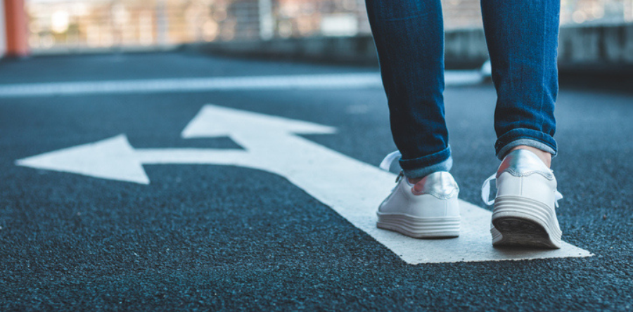 Person walking on a white arrow on street