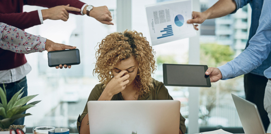 Image of woman sitting at desk trying to cope with work demands