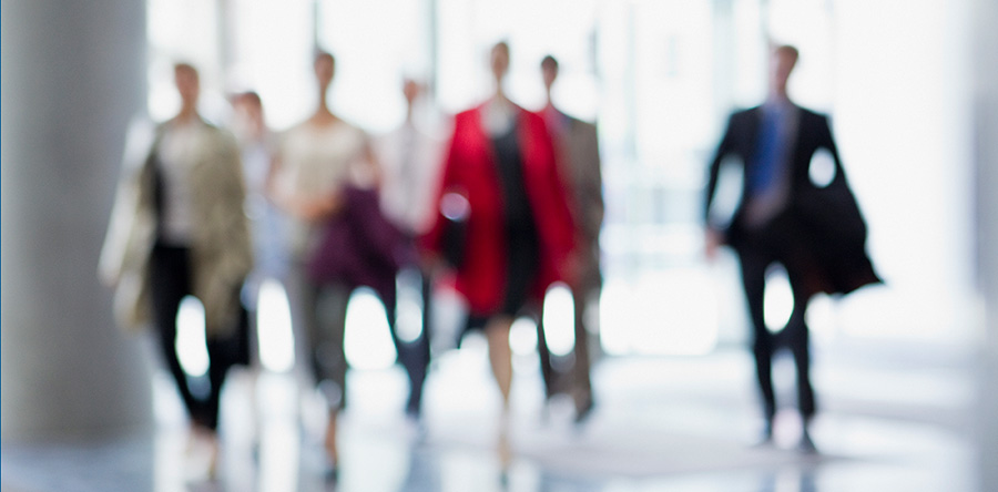 Abstract blurry image of professionals walking forward in a group
